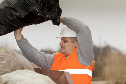 Recyclable materials being loaded into an enclosed skip in Eltham